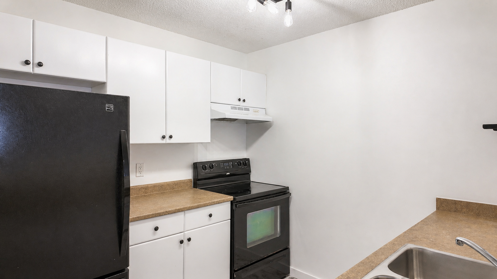 Kitchen with white cabinetry and stove